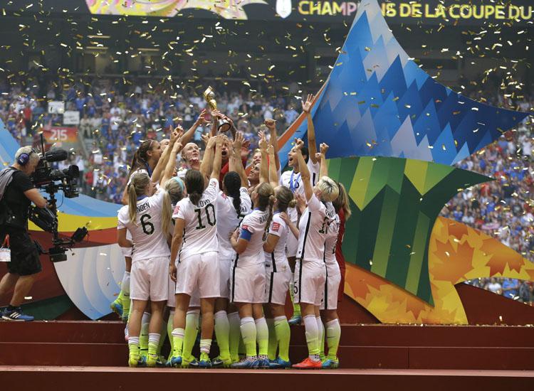 FILE - In this July 5, 2015 file photo, confetti floats down as the United States Women's National Team women celebrate with their trophy after beating Japan 5-2 in the FIFA Women's World Cup soccer championship in Vancouver, Canada. On Friday July 10, 2015,  in New York, the team will make their way through swirling ticker tape up Broadway's Canyon of Heroes to a ceremony at City Hall, where they will be the first national team since 1984 and the first all-female team ever to be honored with the iconic parade. (AP Photo/Elaine Thompson, File)