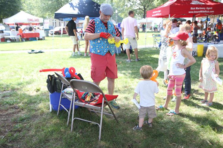 A young festival atendee awaits his balloon animal. The festival had events for all ages to enjoy. 