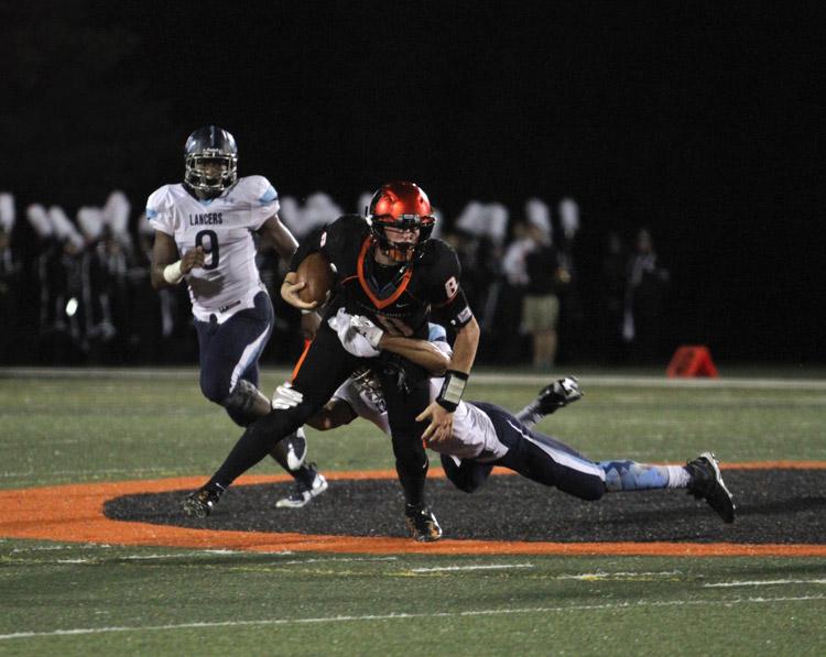 Senior quarterback Riley Jones is tackled during a game against Belleville East. 