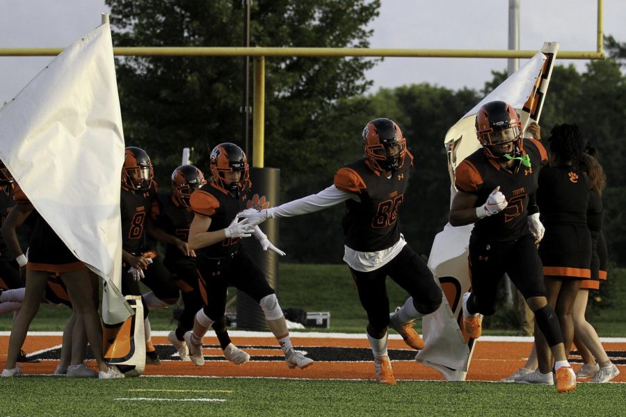 The varsity football team runs through the banner before their season opener on Aug. 24.