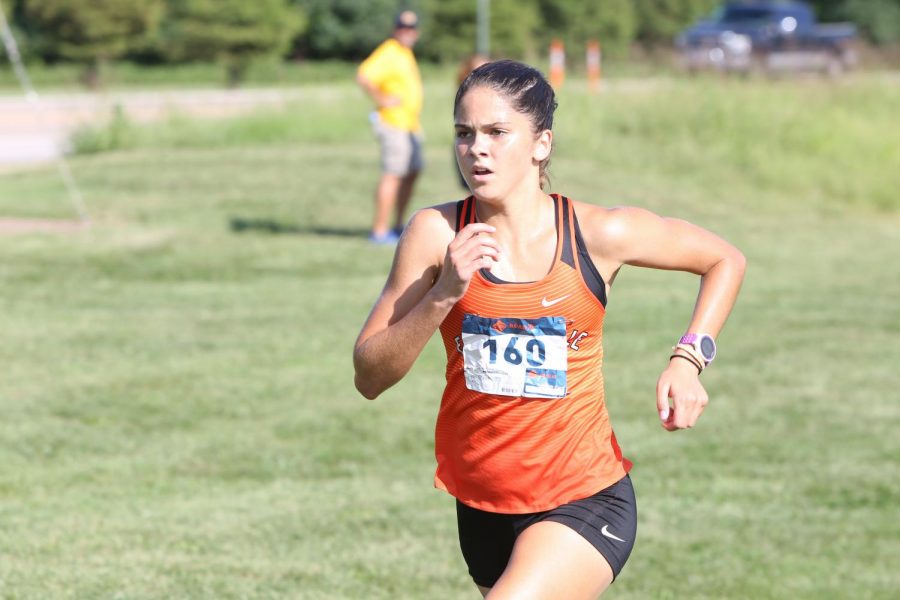 Junior Abby Korak sprints down the last stretch of the course before crossing the finish line.