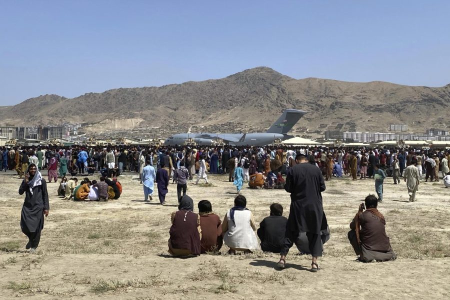 Families wait outside the perimeter of the airport in Kabul on Aug. 16.