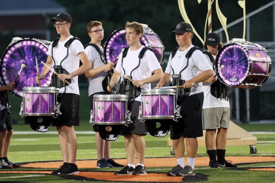 Senior Jack Busse, junior Will Dorsey, senior Carter Schwalb,  sophomore Sam Vuagniaux and senior Kaleb Hollis perform in the percussion line during the band's exhibition on Aug. 6. The show, titled "Carnival Mystique," will be performed at several competitions this season.