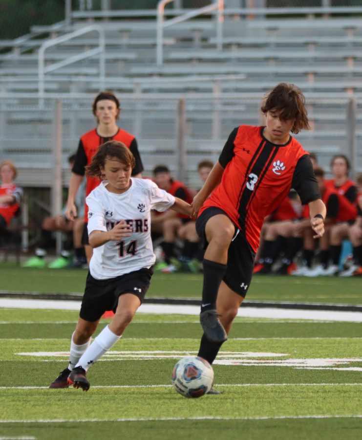 Junior Tyler Dacus and Sophmore Liam Lclean battle for ball while Junior Sam Reader waits for next play.