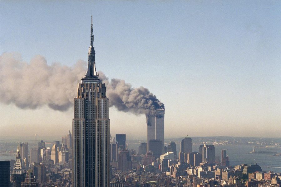 In this Sept. 11, 2001,  photo, the twin towers of the World Trade Center burn behind the Empire State Building in New York City.