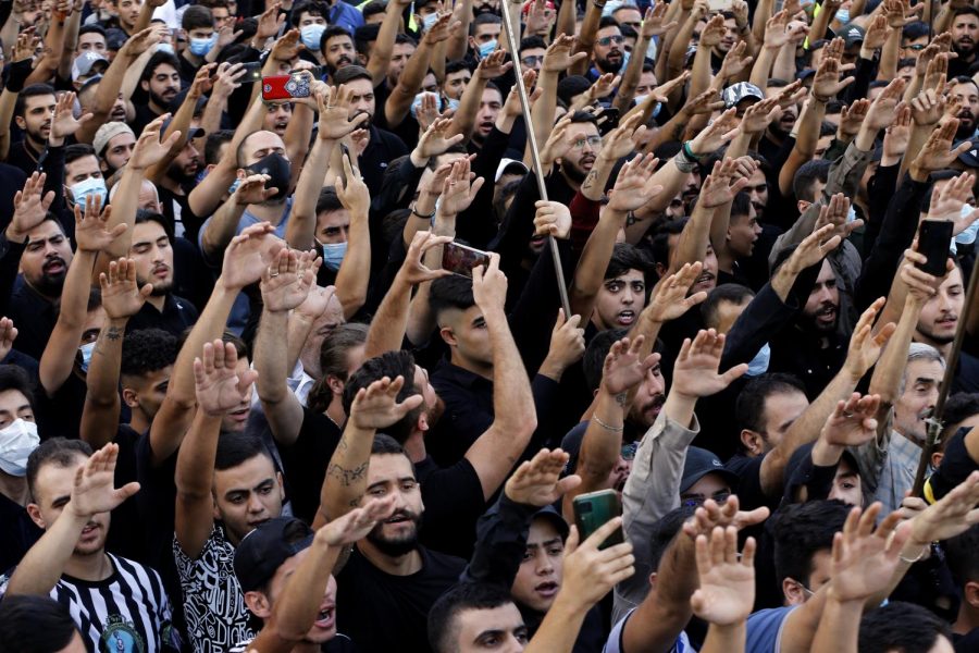 Large groups of Lebanese mourners raised their hands at the funeral of three Hezbollah supporters killed Thursday.