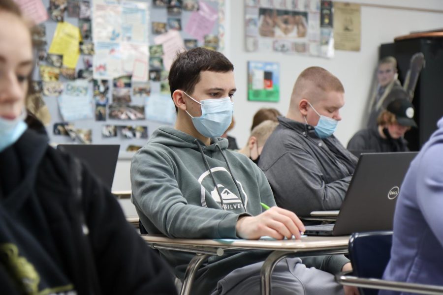 students sit in class with their laptops out as they work on an assignment on Jan. 28. 