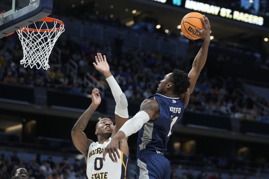 Saint Peter's KC Ndefo (11) goes up for a dunk against Murray State's KJ Williams (0) during a game in the second round of the NCAA tournament, Saturday, March 19, 2022, in Indianapolis.