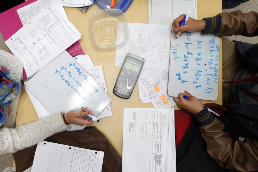 Students solve problems in a pre-calculus class.