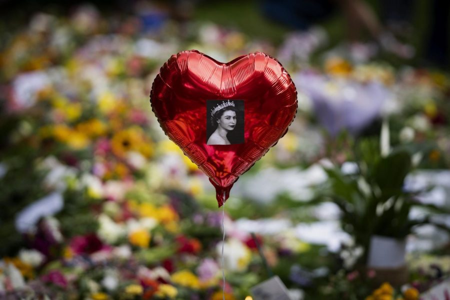 A balloon with a picture of Queen Elizabeth II on it sits at a memorial near Buckingham Palace.