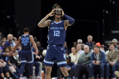 Memphis Grizzlies guard Ja Morant adjusts his face guard in the second half of an NBA basketball game against the Houston Rockets.