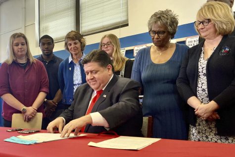 Illinois Gov. J.B. Pritzker signs a legislation regarding the teacher shortage at Springfield High School on April27, 2022.