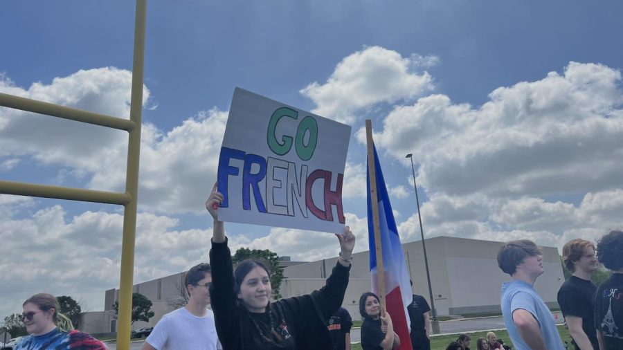 Senior+Ivanna+Gonzalez%2C+a+French+student%2C+holds+up+a+sign+during+the+kickball+game+against+the+German+students+on+May+9.+The+sign+was+signed+by+most+of+the+French+students+on+the+back+during+the+game.