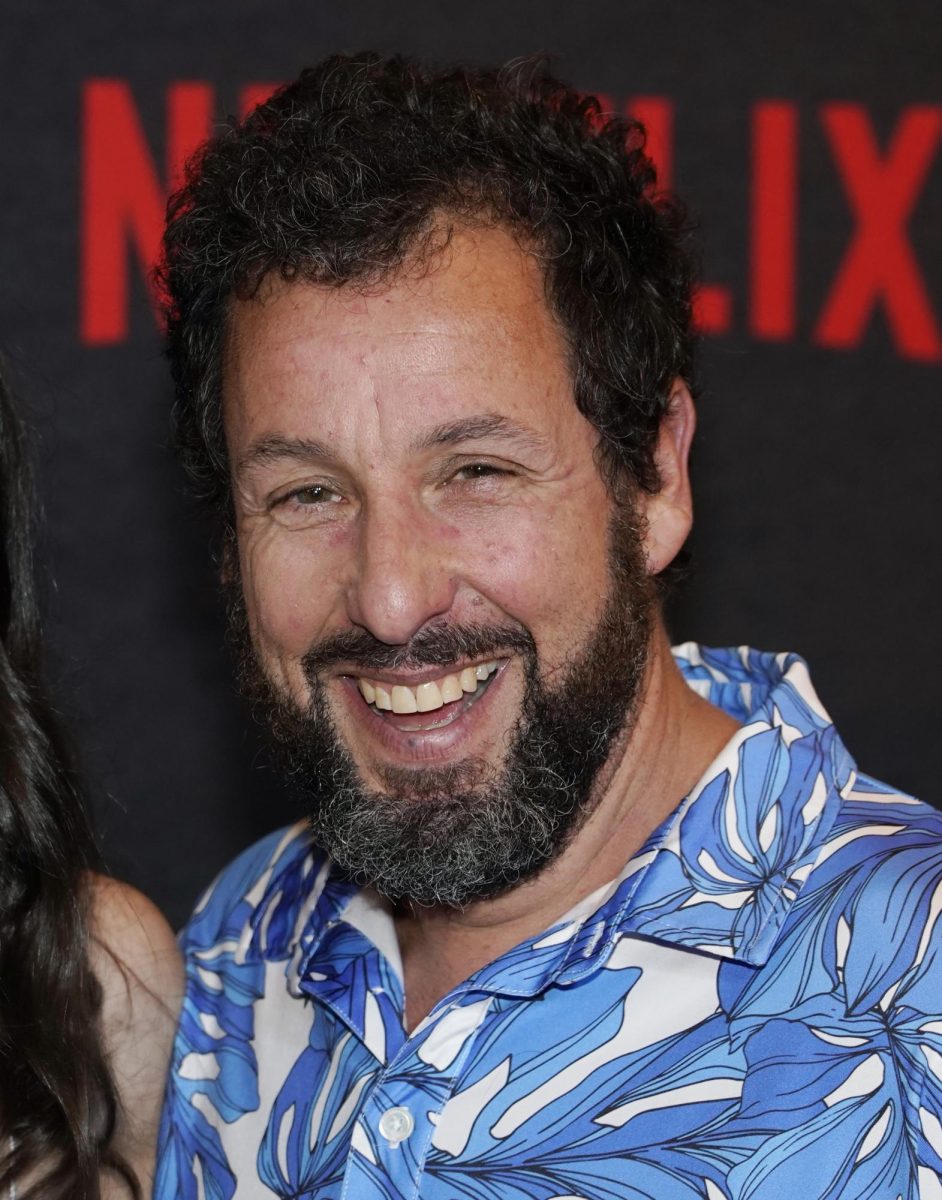 Adam Sandler appears smiling on the Netflix red carpet for his new movie.