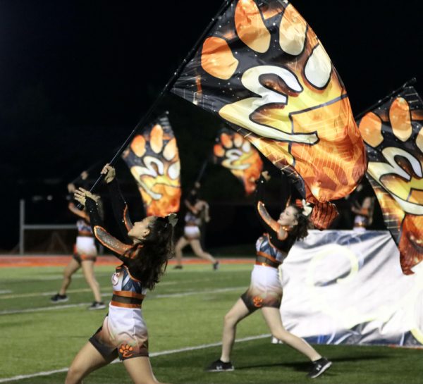 Serena Caldarola and Gwen Harkey perform with color guard at Fridays football game.