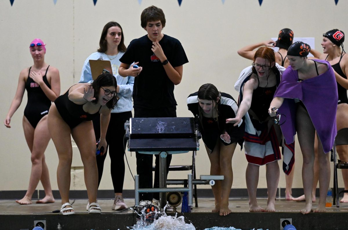 Members of the EHS swim and dive team cheer on junior Karis Chen as she competes in the 100-yard breaststroke on Oct. 5 against Glenwood.