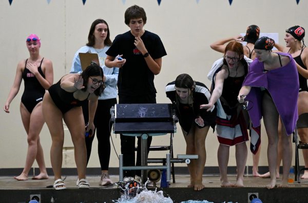 Members of the EHS swim and dive team cheer on junior Karis Chen as she competes in the 100-yard breaststroke on Oct. 5 against Glenwood.