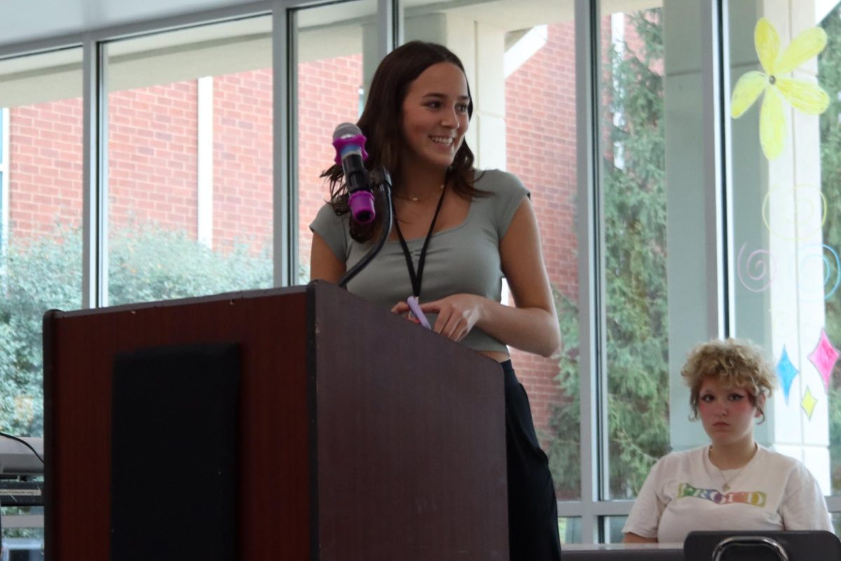 Junior Liliana Berman reads her selection at Creative Writing Club's fall poetry slam in the cafeteria, Oct. 26.