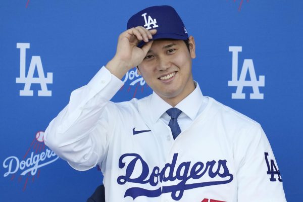 Shohei Ohtani puts on the Dodger cap for the first time at his signing press conference.