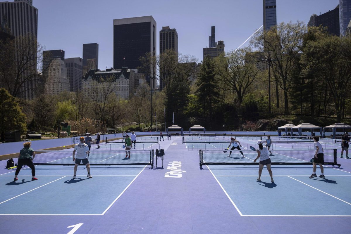 A group of students play pickleball in the park.