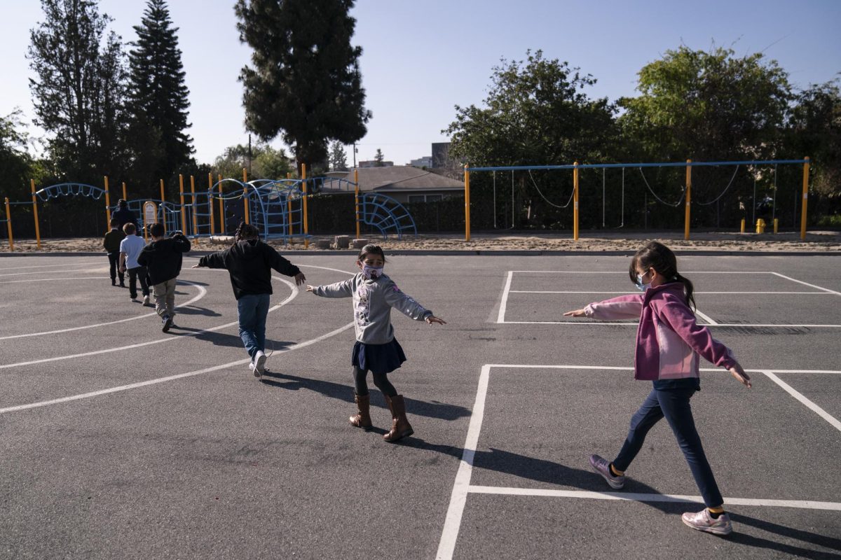 Second grade students spread their arms for social distancing as they walk to a playground at West Orange Elementary School in Orange, Calif., Thursday, March 18, 2021. The school has been hybrid since fall last year. I love seeing kids being kids, said Dana Johnston, the schools instructional specialist. Being able to see kids have a little slice of normal in our school day has been really great. Its obviously not quite exactly what it used to be, but its one step closer to normal for our kids.